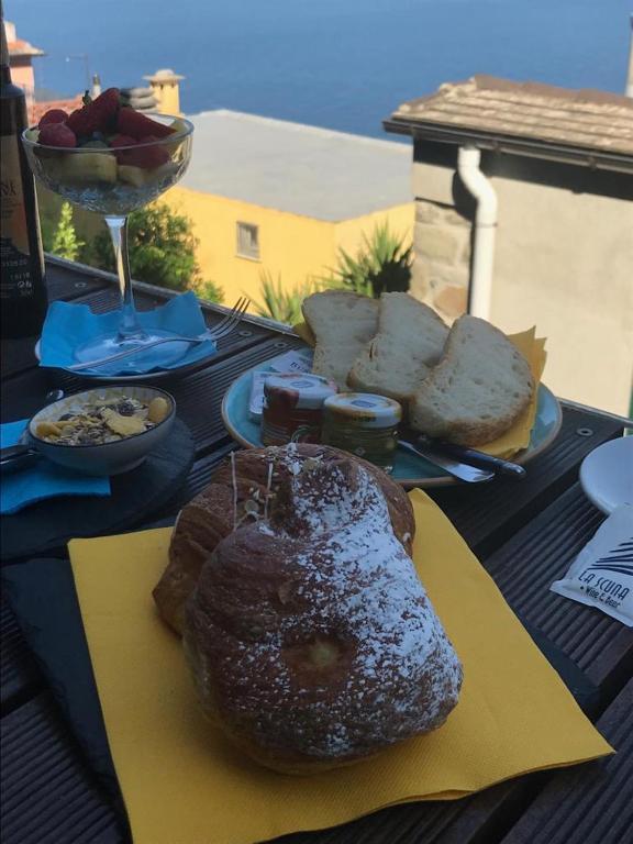 a table with a plate of bread and a pastry at il Magàn - Cinque Terre in Corniglia