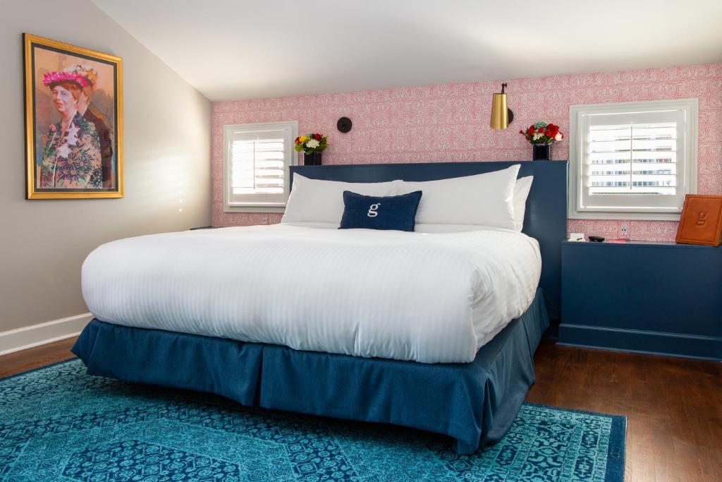 a bedroom with a white bed and a blue wall at The Germantown Inn in Nashville
