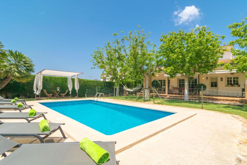 a swimming pool with chairs and a house at Sa Coma Dalies in Sa Coma