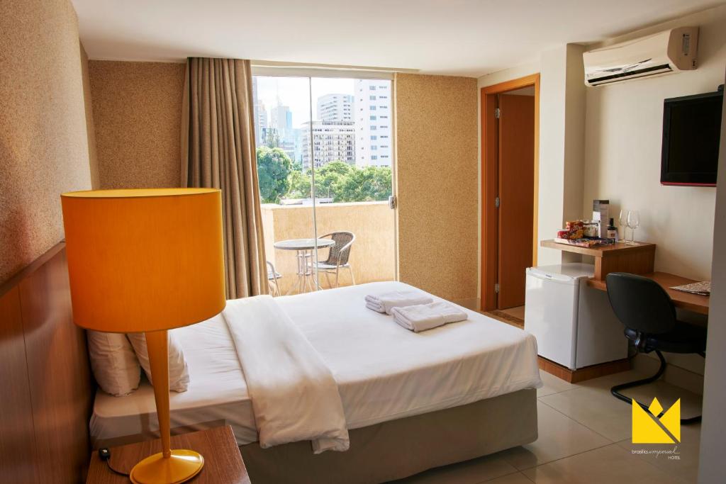 um quarto de hotel com uma cama e uma janela em Brasília Imperial Hotel e Eventos em Brasília