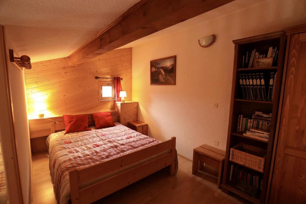 a bedroom with a bed and a book shelf at Le Duplex d&#39;Aussois in Aussois