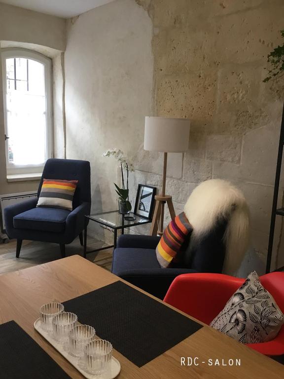 a living room with a table and a couch and a chair at Appartement Arles Centre Historique in Arles