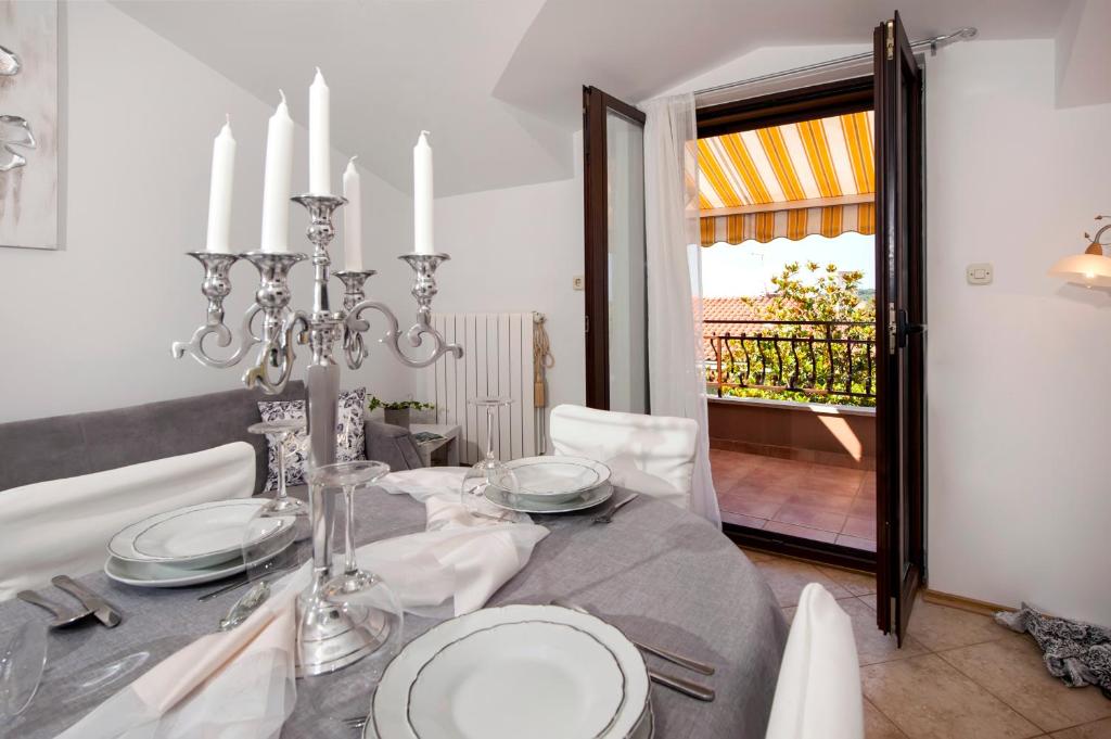 uma sala de jantar com uma mesa com um lustre em Apartment Len em Rovinj