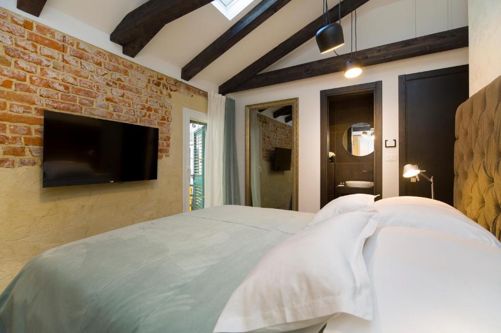 a bedroom with a white bed and a brick wall at LAmenta in Split