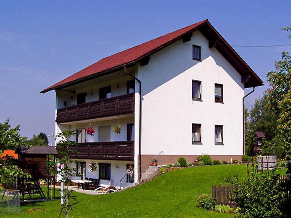 duży biały dom z czerwonym dachem w obiekcie Ferienwohnung Haus Franziska w mieście Neuschönau