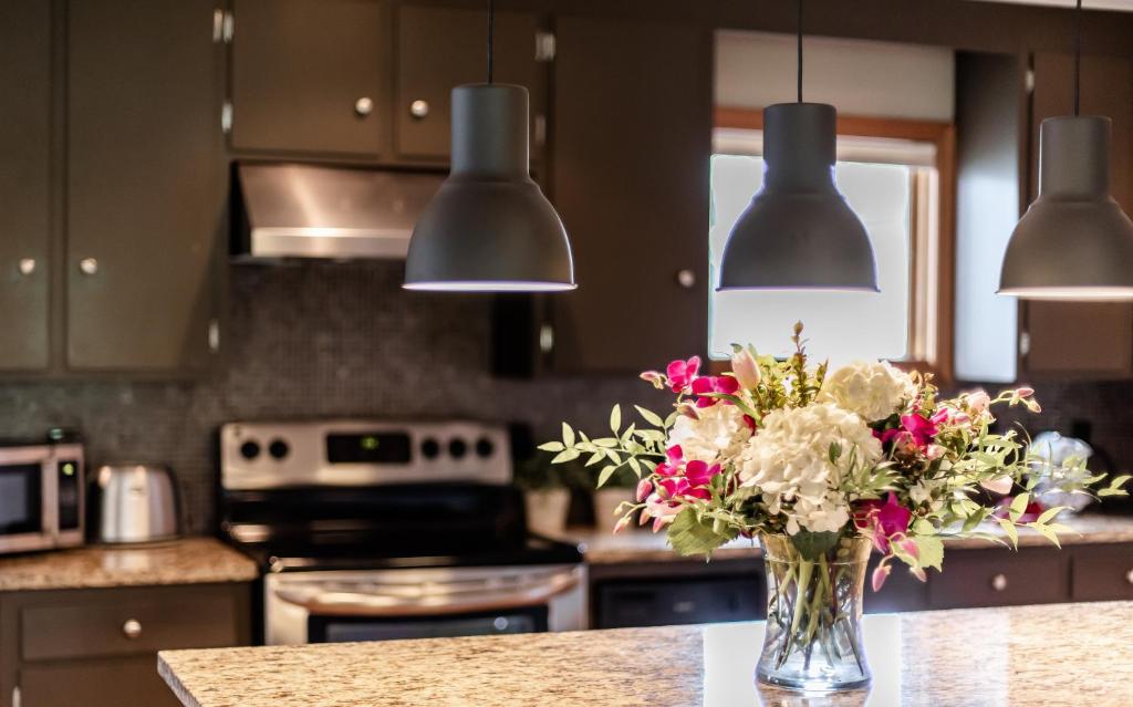 a vase of flowers on a counter in a kitchen at Small Batch Lodging in Granville