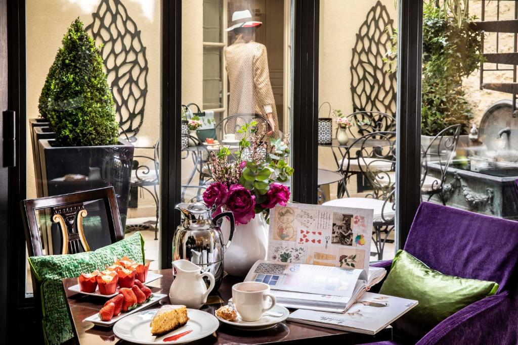 a table with a plate of fruit and a woman in a window at Arioso in Paris