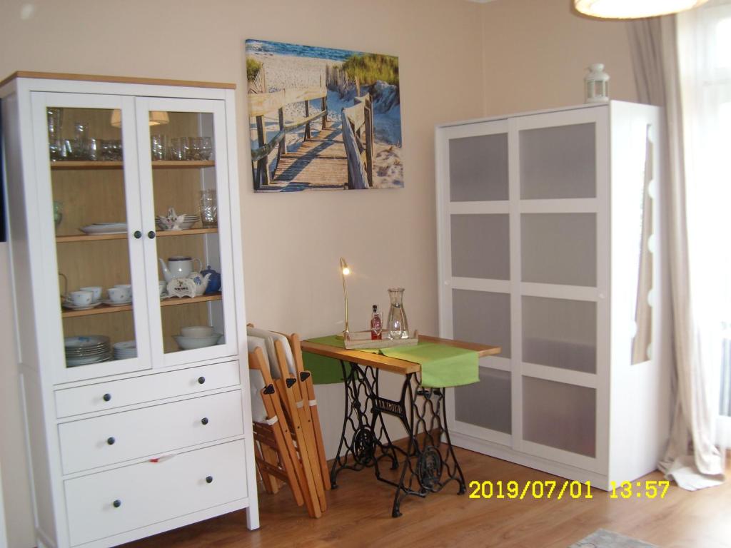comedor con mesa y armario blanco en Apartamenty Wójcik Provans, en Gdynia