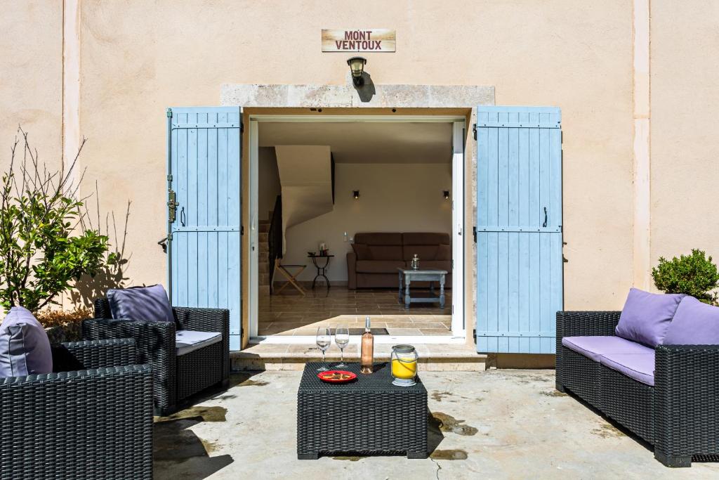 a patio with wicker chairs and a table at Mas Saint Julien in Cavaillon