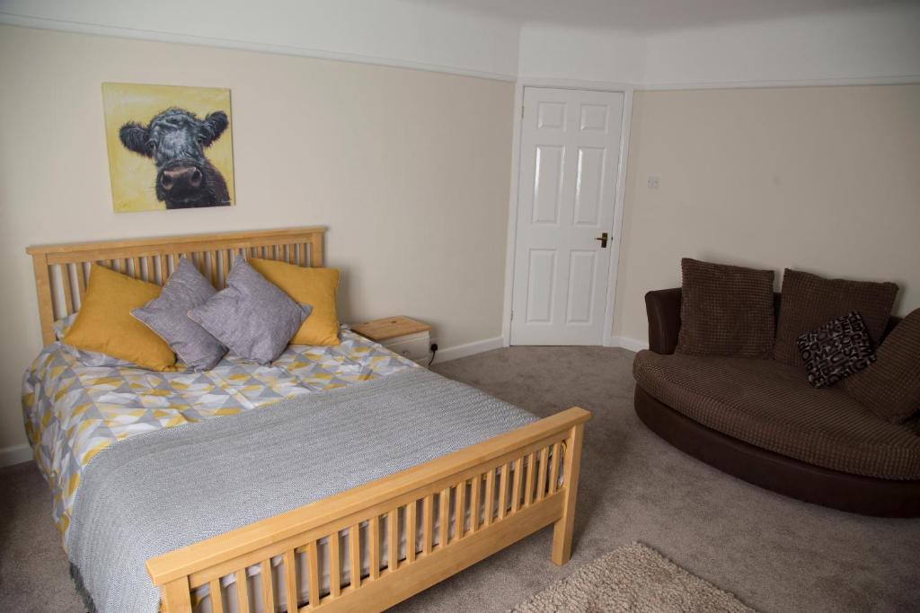 a bedroom with a wooden bed and a couch at Southampton Luxury Peaceful Room in Southampton