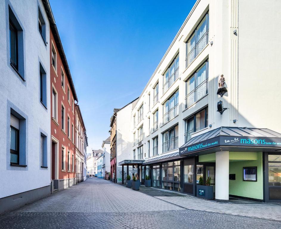 eine leere Straße in einer Stadt mit hohen Gebäuden in der Unterkunft Schroeders City-Style-Hotel in Trier