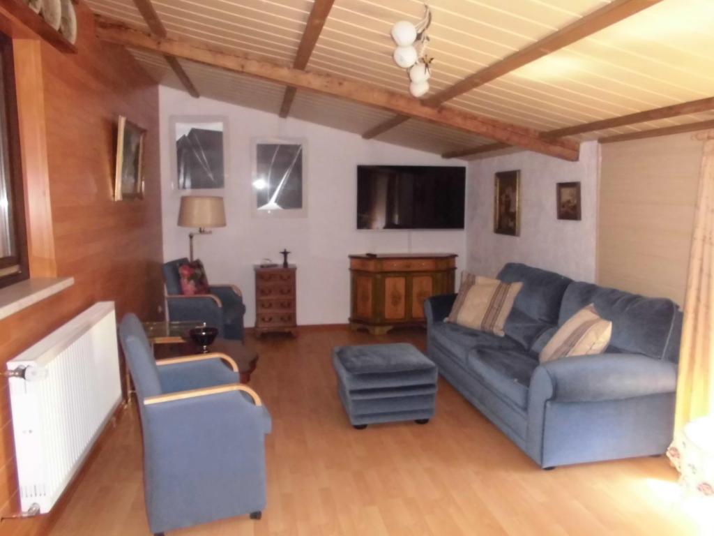 uma sala de estar com um sofá e duas cadeiras em urgemütliche Ferienwohnung im Kraichgauer Hügelland em Eppingen