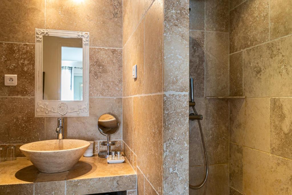 a bathroom with a sink and a mirror and a shower at Mas Saint Julien in Cavaillon
