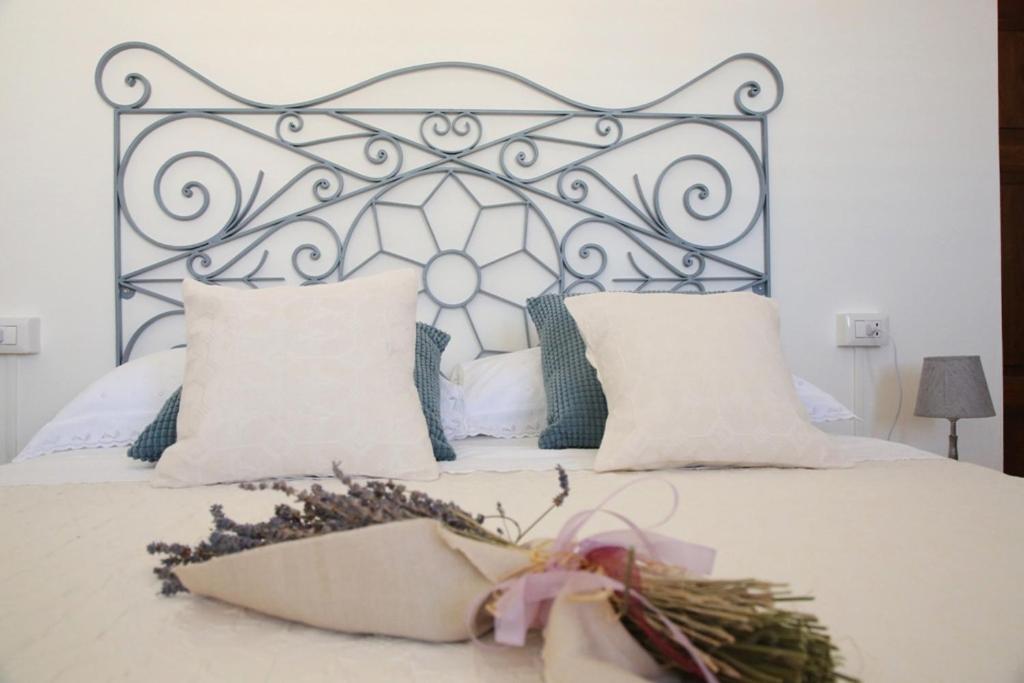a bed with a metal headboard and a flower arrangement on it at DOLCE VITA in Tempio Pausania