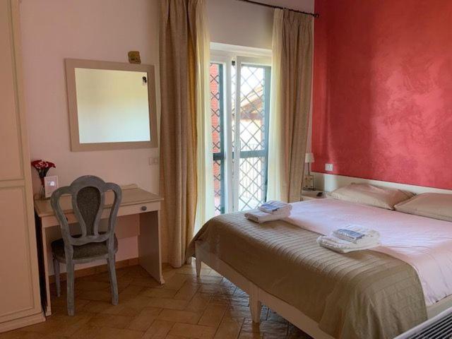 a bedroom with a bed and a desk and a window at B&B I 4 Sentieri in Castel San Pietro Romano