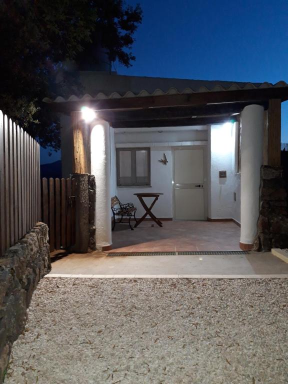 un patio con garaje blanco por la noche en Casa Toloi, en Dorgali