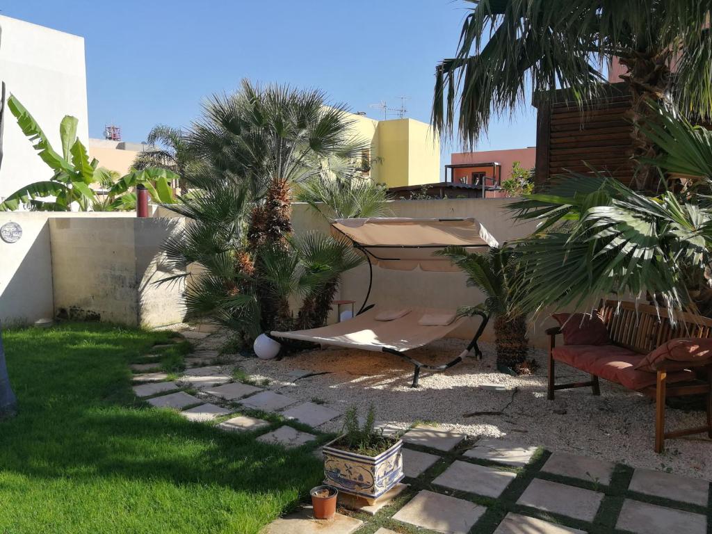 a garden with palm trees and a piano in a yard at Villa Favignana in Favignana