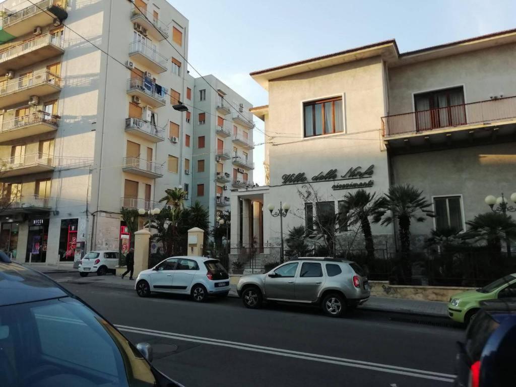 two cars parked on a street next to buildings at La casa del Professore in Catania