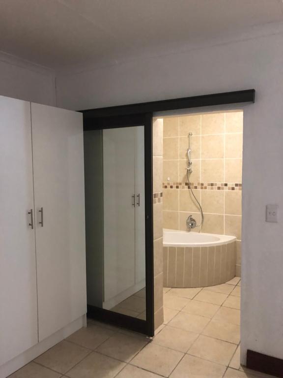 a bathroom with a shower and a bath tub at Sweet Home Alibama in Nelspruit