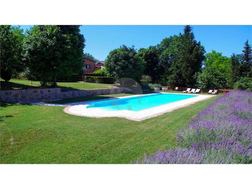 ein Schwimmbad in der Mitte eines Gartens in der Unterkunft Agriturismo Ca' Andreana in Urbino