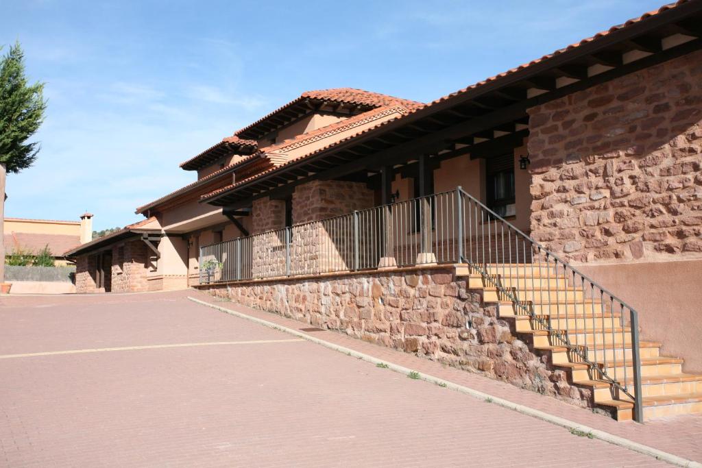 um edifício de tijolos com escadas e uma parede de pedra em CASA RURAL MIRALTAJO em Corduente