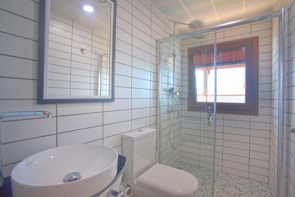 a bathroom with a toilet and a sink and a shower at Sunset Villa Hotel in Kaş