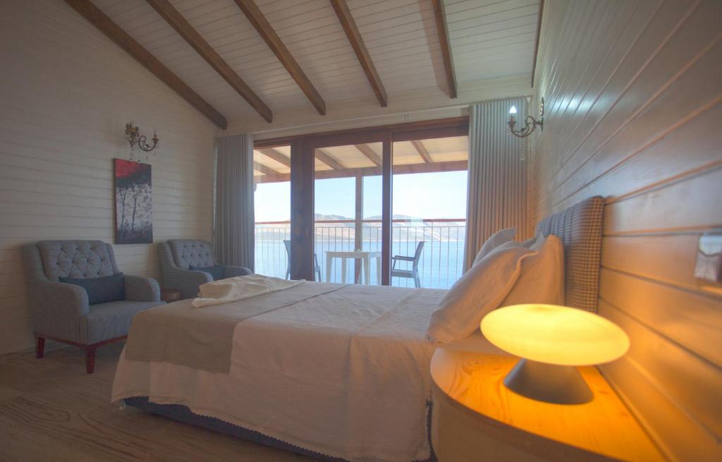 a bedroom with a bed and a table and a chair at Sunset Villa Hotel in Kaş