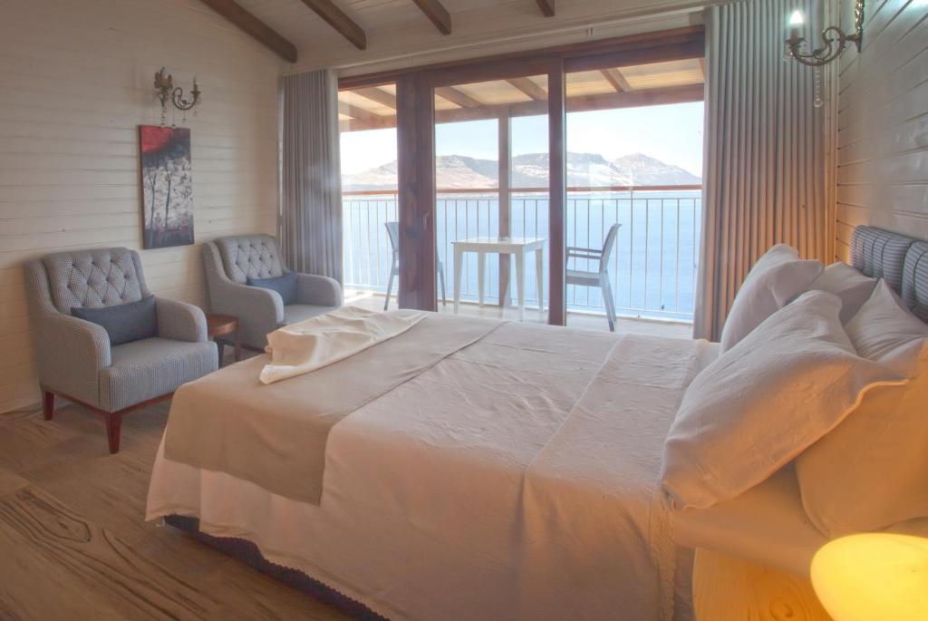 a bedroom with a large bed and a balcony at Sunset Villa Hotel in Kaş