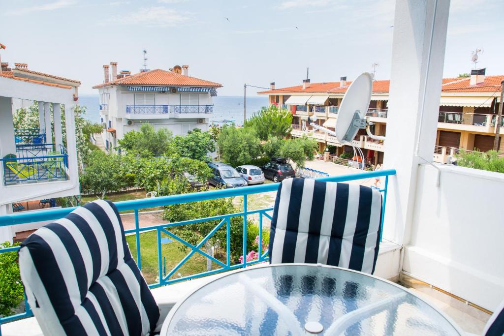 - Balcón con mesa de cristal y 2 sillas en Alexger Gerakini Beach house view, en Gerakini