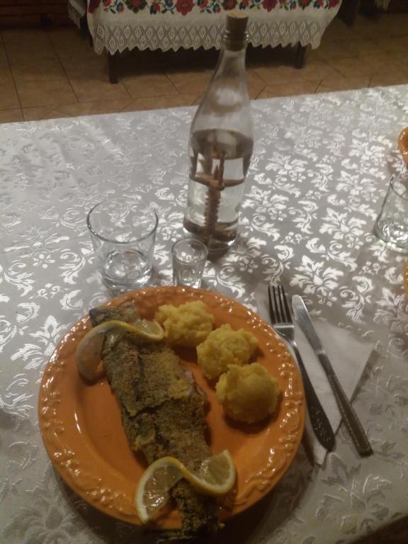 a plate of food on a table with a bottle at Cabana Victor in Sighetu Marmaţiei