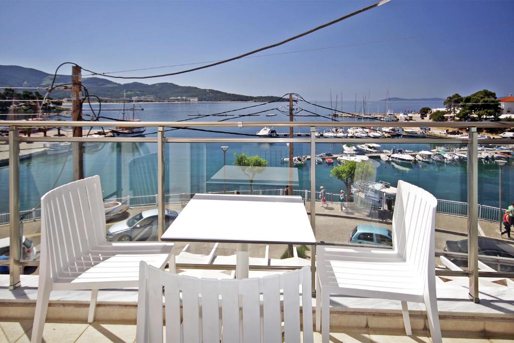 a table and chairs on a balcony with a marina at Aqua Marine 2 in Neos Marmaras