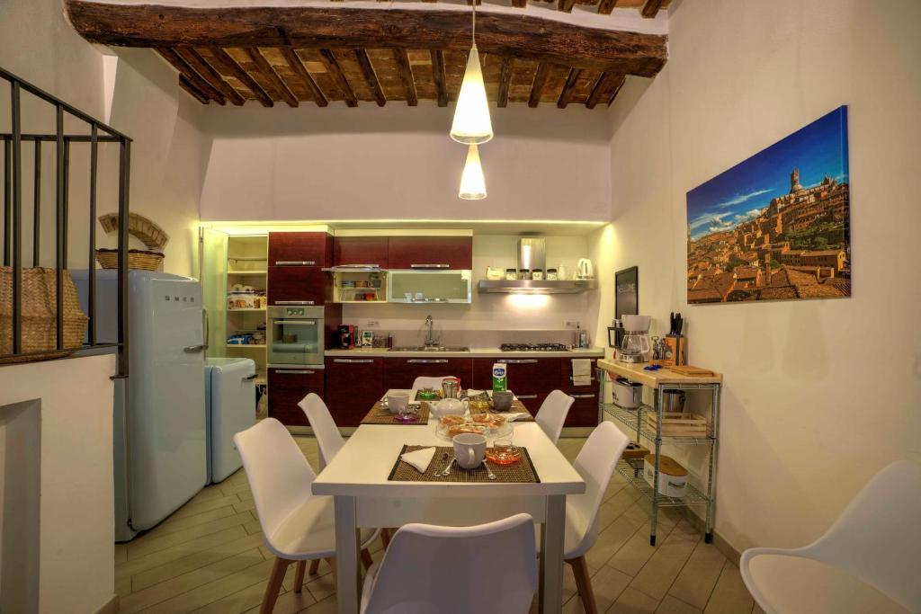 - une cuisine et une salle à manger avec une table et des chaises dans l'établissement Cozy Apartment in the heart of Siena, à Sienne