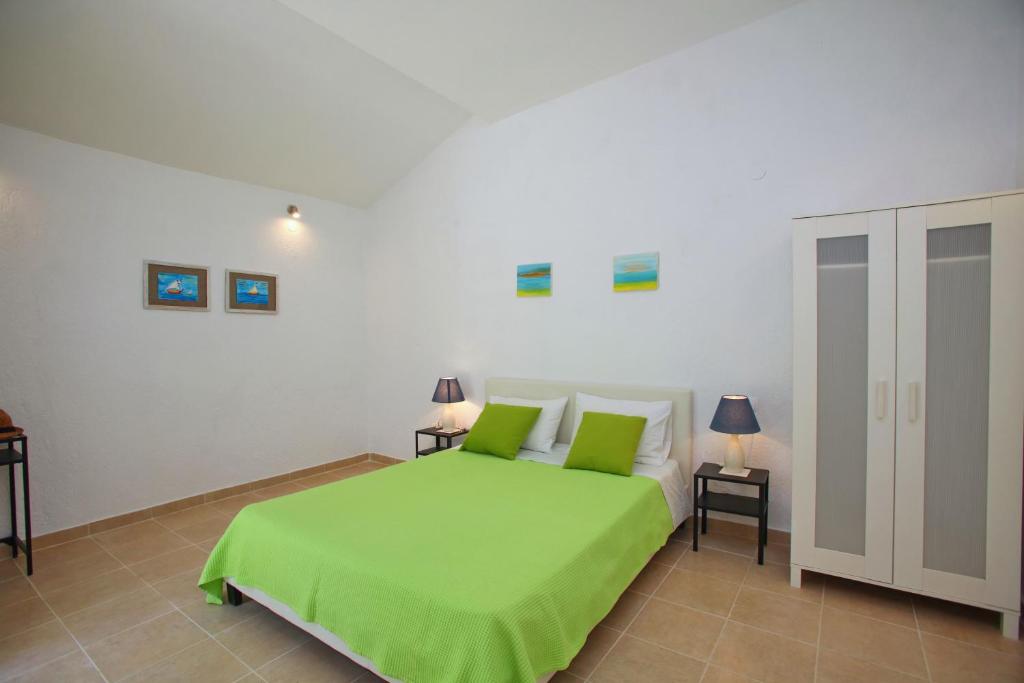 ein Schlafzimmer mit einem grünen Bett und zwei Nachttischen in der Unterkunft Liogerma Cottage in Panormos Skopelos