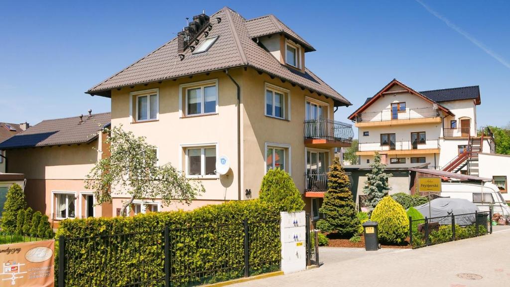 une grande maison avec une clôture devant elle dans l'établissement Pokoje Gościnne Lidka, à Dziwnów