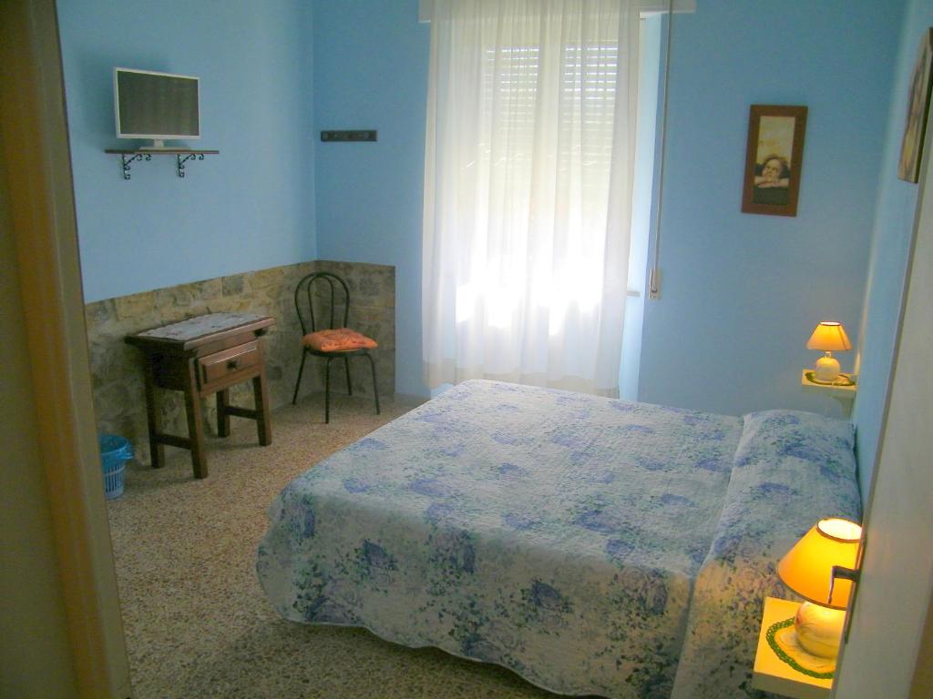 een slaapkamer met een bed, een bureau en een televisie bij Home89 in Lucca