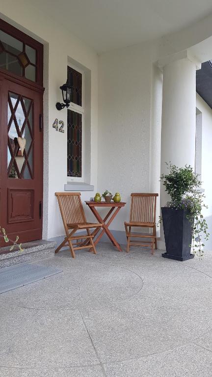 dos sillas y una mesa frente a una puerta en Moltke-Villa, en Teterow