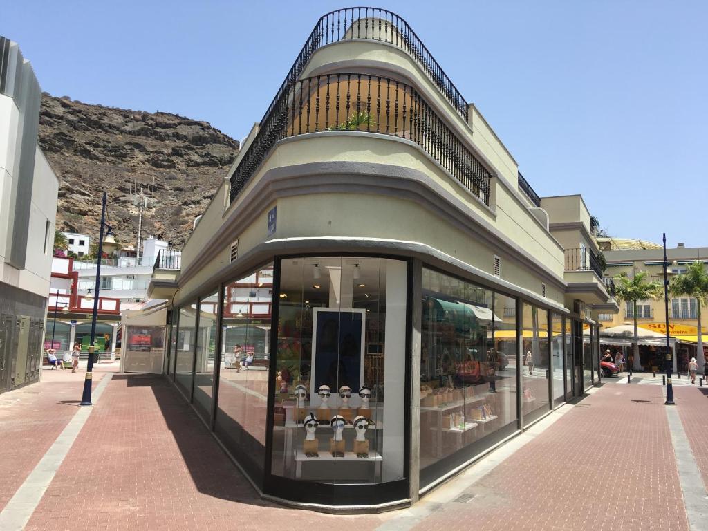 una tienda con ventanas de cristal en una calle en Edificio Playa en Puerto de Mogán