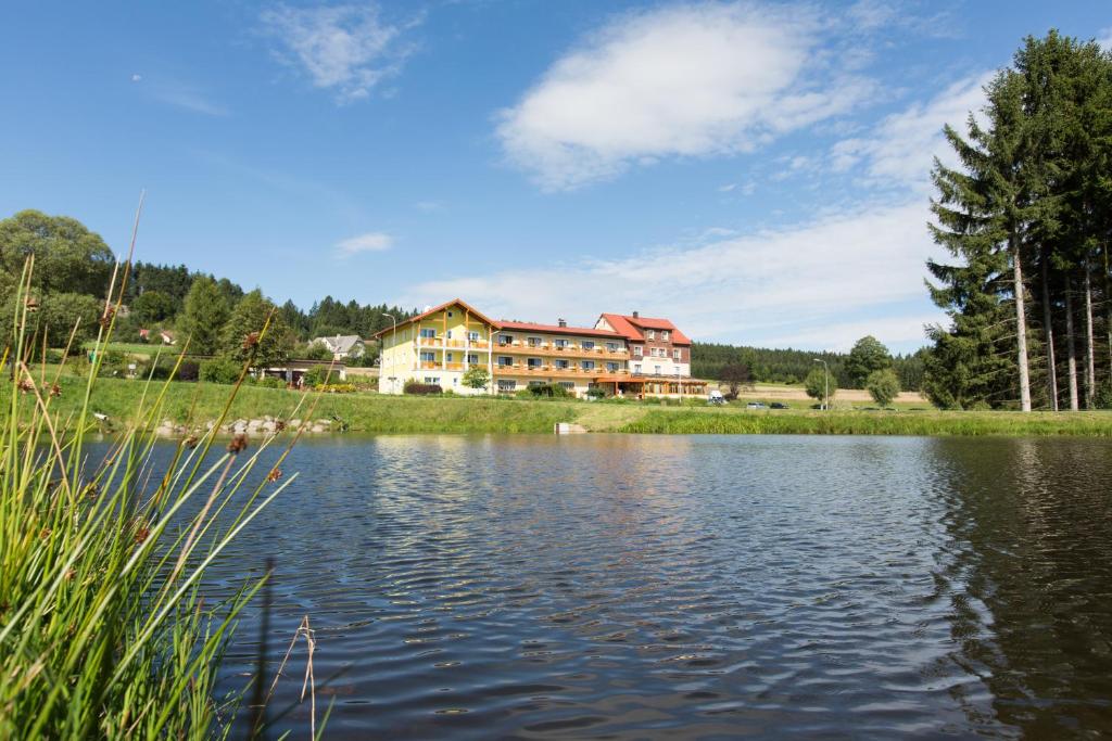 Gasthof-Pension Nordwald في Harbach: جلسة منزل على جانب البحيرة