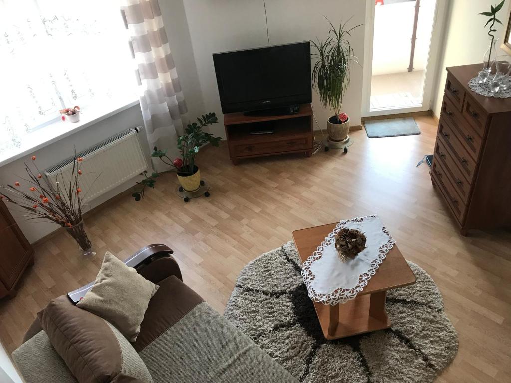 a living room with a couch and a tv at Mieszkanie Jadwigi in Giżycko