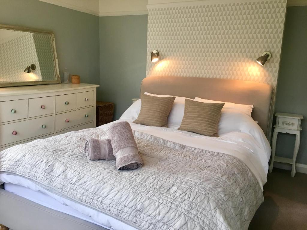 a bedroom with a bed with two towels on it at The Cornish Retreat in Bude