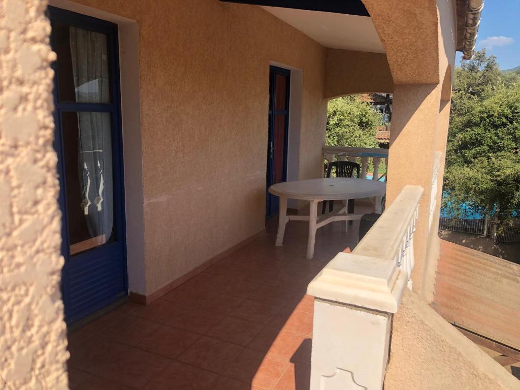 a balcony with a table and a blue door at Résidence l’incantu in Olmeto