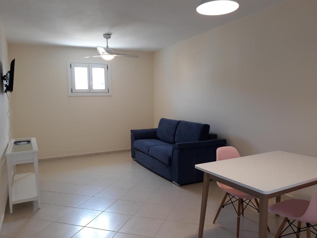 a living room with a blue couch and a table at Monolithos Villas in Kipri