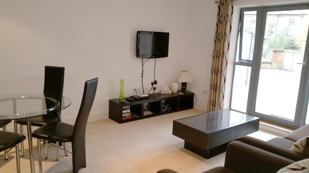 uma sala de estar com um sofá, uma mesa e uma televisão em Oxford Apartment- Free parking 2 Bedrooms-2Bathrooms-Located in Jericho Oxford close to Bus and Rail sation em Oxford