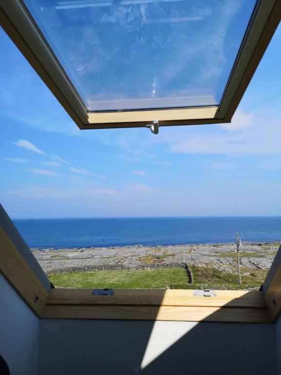 a window in a room with a view of the ocean at An Creagán Rooms in Inisheer