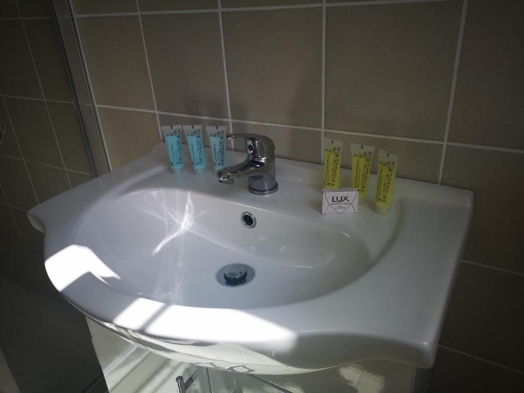 a white bathroom sink with toothbrushes on it at An Creagán Rooms in Inisheer