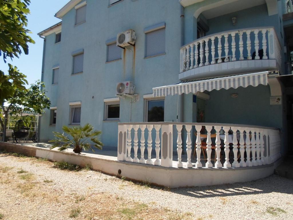 un bâtiment bleu avec une clôture blanche devant lui dans l'établissement Zaton - Nin Family apartment, à Zaton