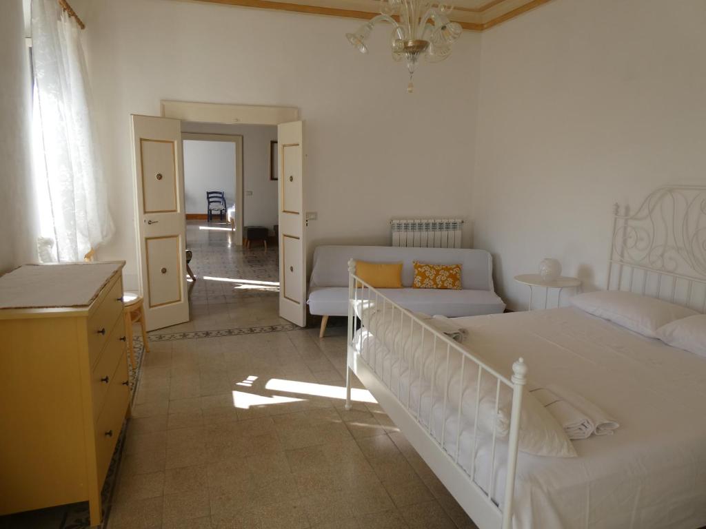 ein weißes Schlafzimmer mit einem Bett und einem Sofa in der Unterkunft Casa Diamanti-Fox 33 Via Guglielmo Marconi in Sonnino