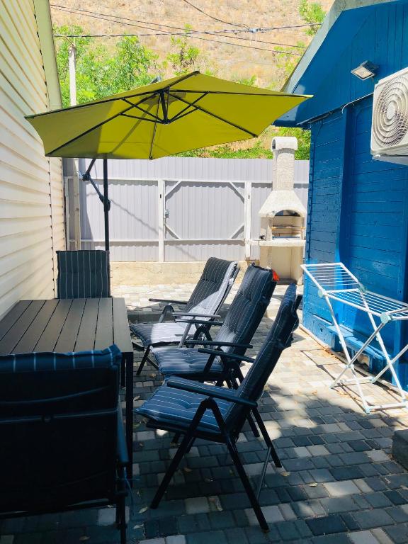 two chairs and a table and an umbrella on a patio at Дача у моря in Vapnyarka