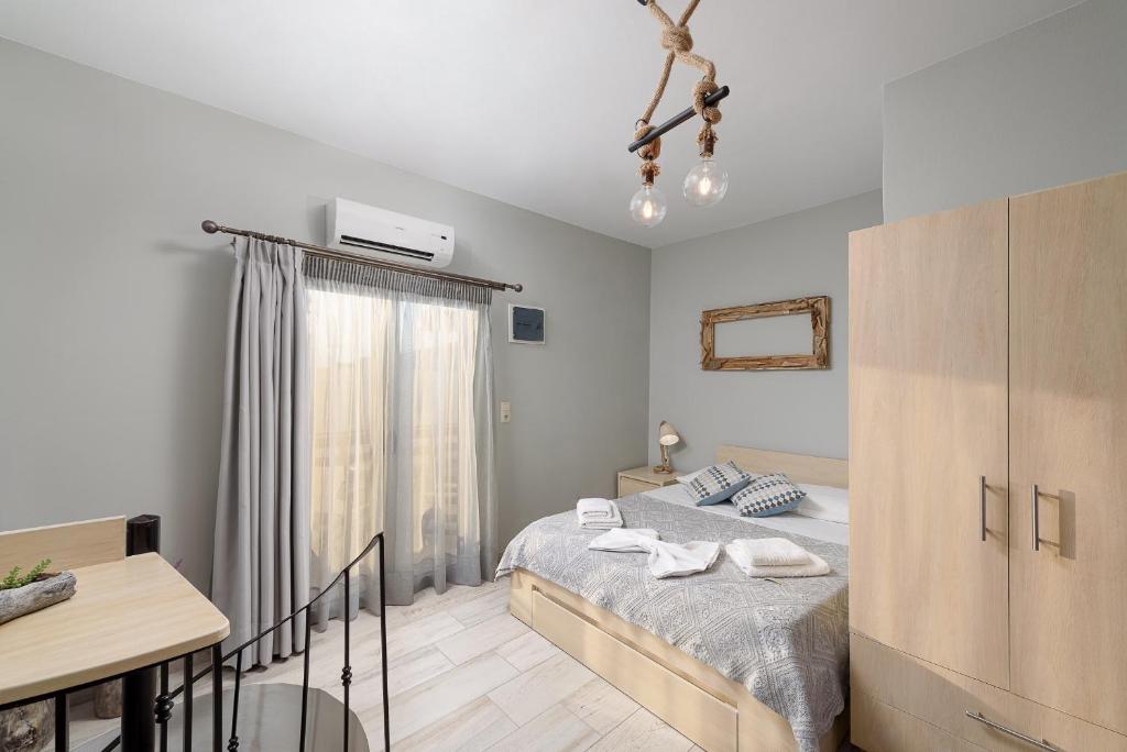 a bedroom with a bed and a desk and a window at Ageliki Studio in Matala