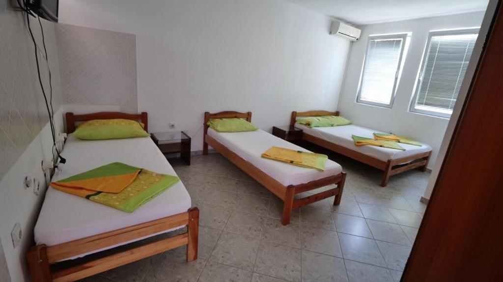 um quarto com três camas num quarto em Familien Apartment Zeno em Ulcinj